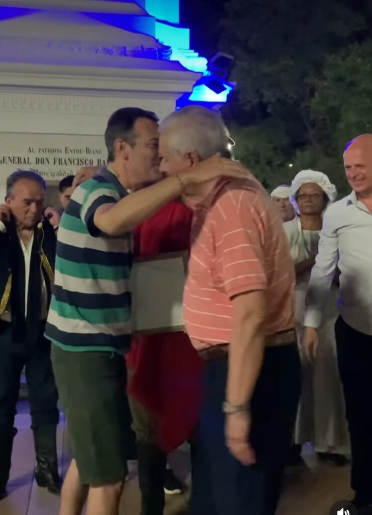 Abrazo entre Federico Ferreyra y el intendente Eduardo Lauritto al entregale un reconocimiento. Se observa detràs parte del elenco y otros funcionarios de Concepciòn del Uruguay.